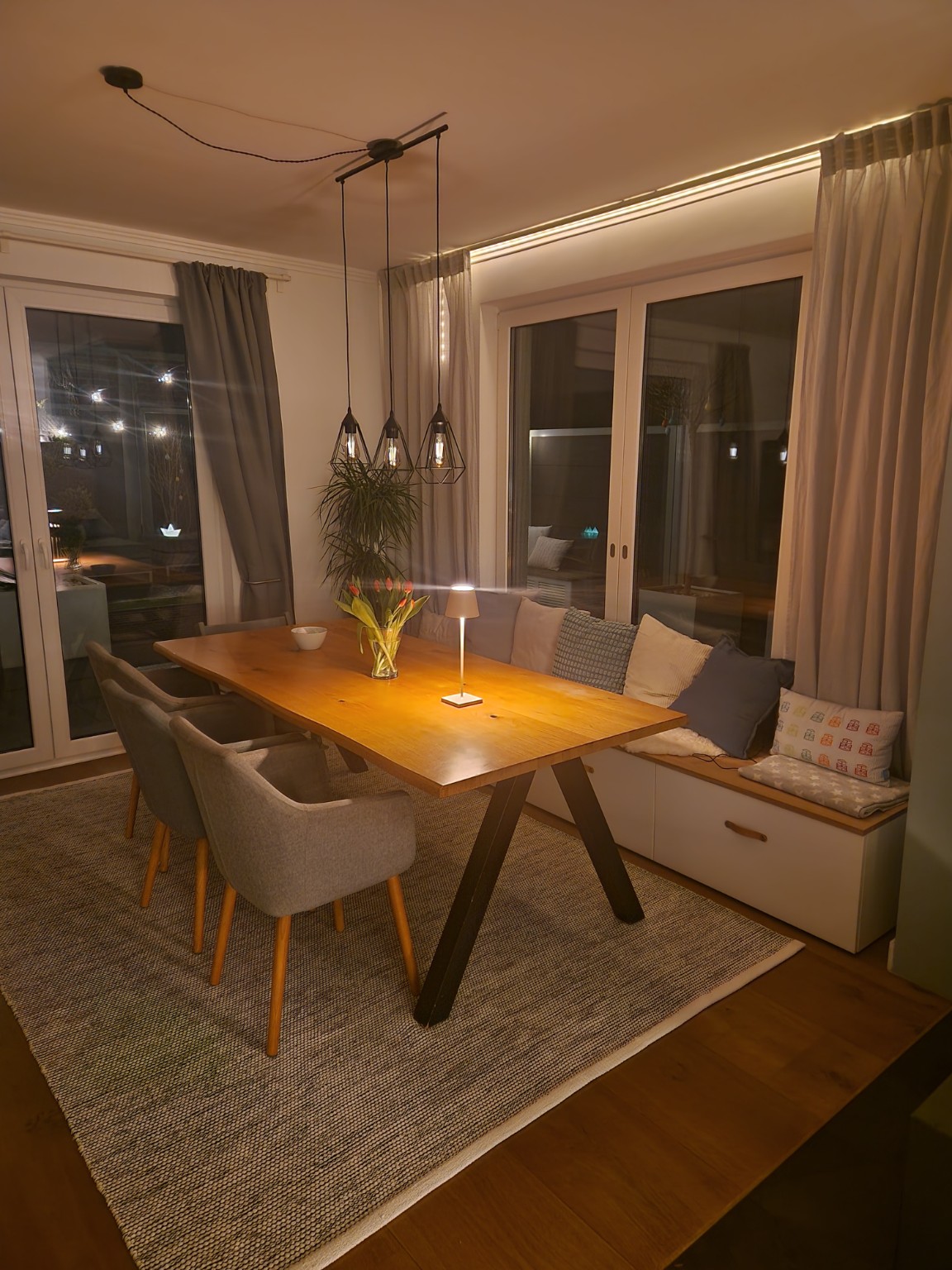 Essbereich mit Sitzbank, Stauraum und warmer Beleuchtung.