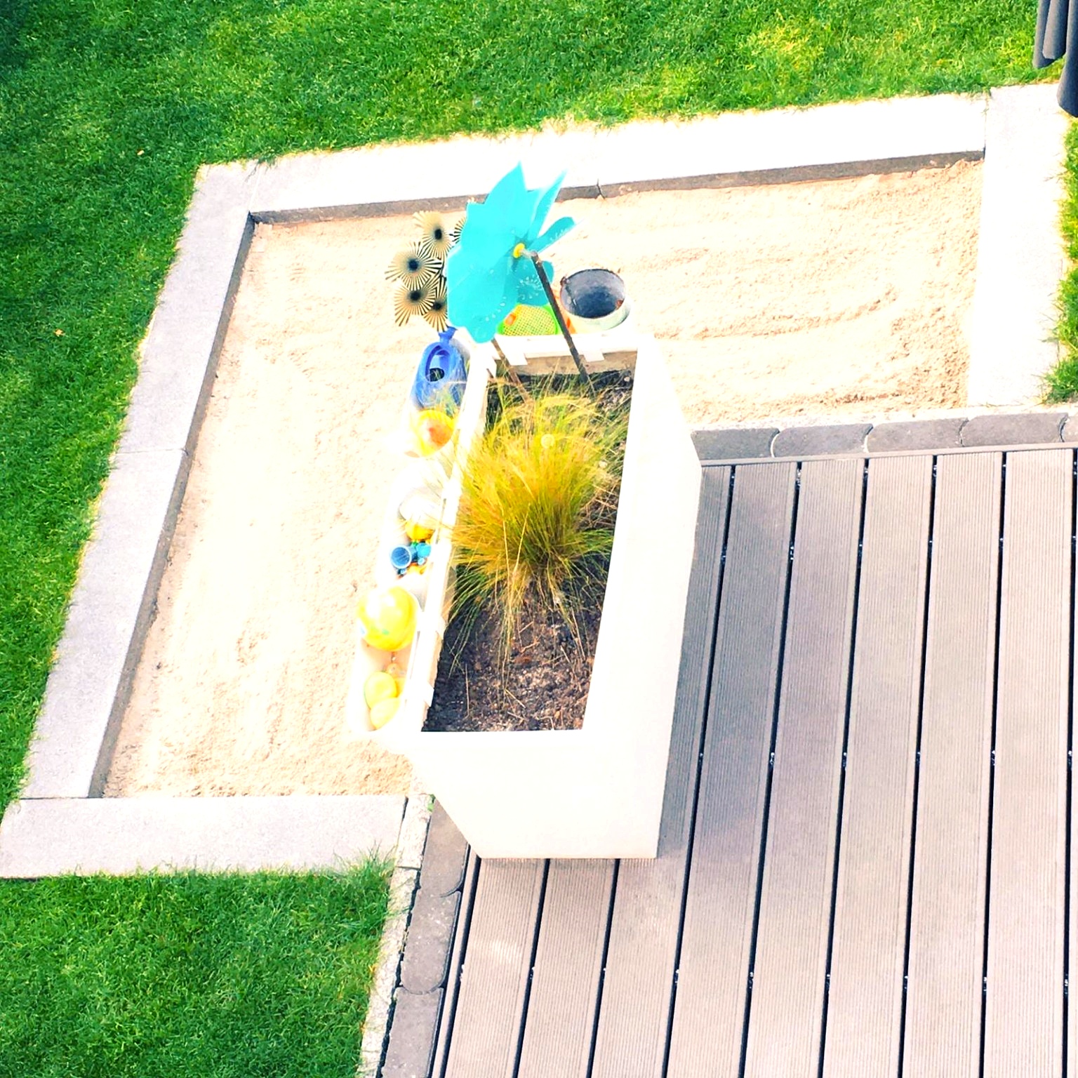 Sandkasten und Pflanzkasten im Garten.
